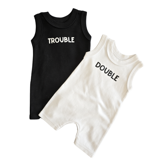 Black Romper with 'TROUBLE' and white romper with 'DOUBLE' text on