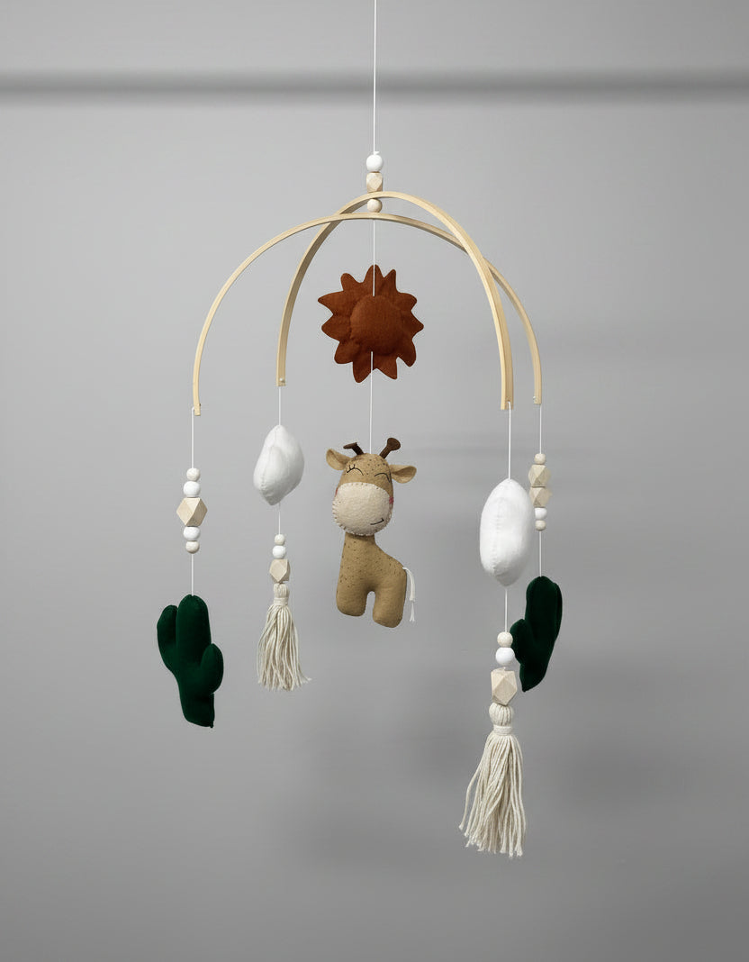 Baby mobile with hanging toys and decorations on a plain background