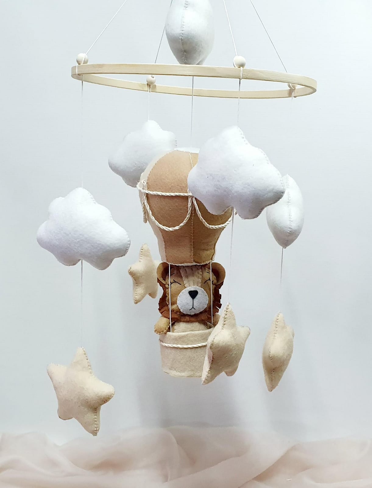 Children's mobile with teddy bear in a hot air balloon, clouds, and stars on a white background