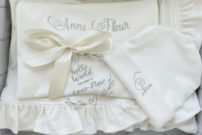 Personalised embroidered White baby outfit with ruffles and embroidered text on a white background