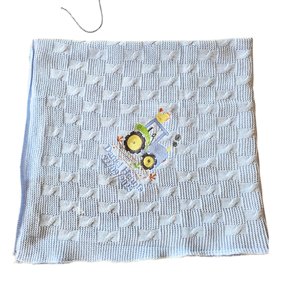 Textured blanket with a embroidered design on a white background