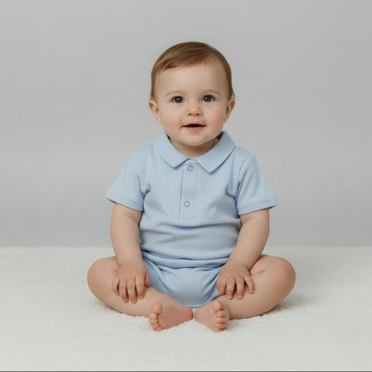 Light blue children's outfit with shorts, sippy cup, and sunglasses on a gray background