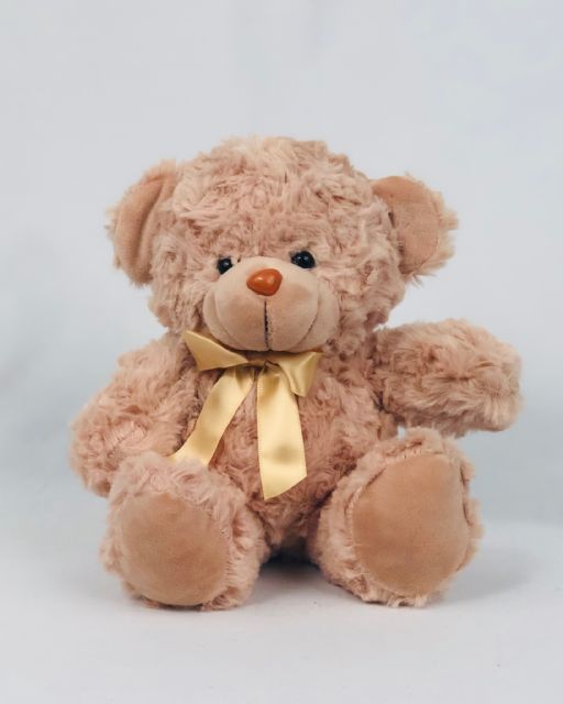 A Fluffy teddy bear with a chocolate brown body, soft beige arms and legs, and a cozy cream-colored stomach. It is wearing a gold bow tie.