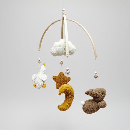 Baby mobile with plush toys including a duck, star, and rabbit on a white background
