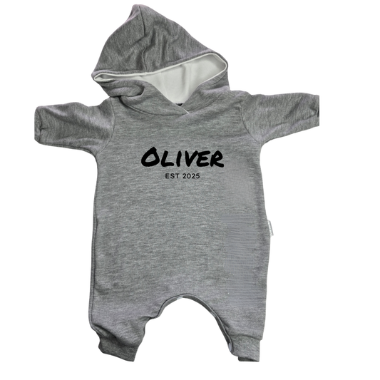 Gray baby onesie with 'OLIVER EST 2025' text on a white background