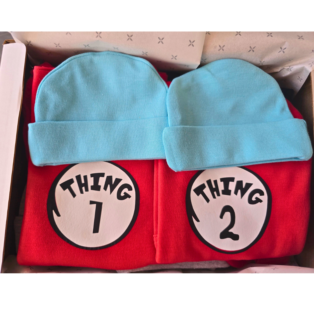 Red shirt with 'Thing 1' and 'Thing 2' labels and blue hats in a box.